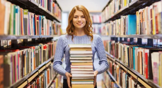 Happy-Woman-Holding-Books-in-Library